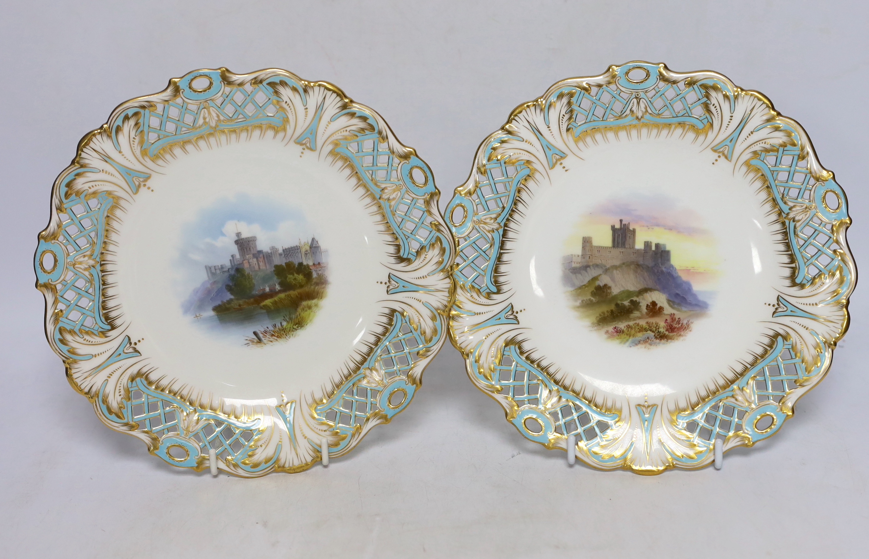 A pair of Mintons bone china dishes, with painted central cartouches of Windsor and Bamborough Castles, 22.5cm diameter